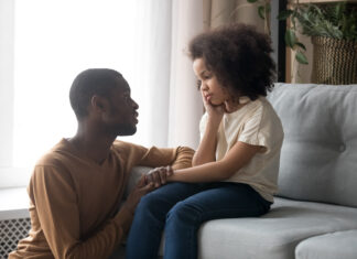 Supportive black dad talk cheering sad preschooler daughter