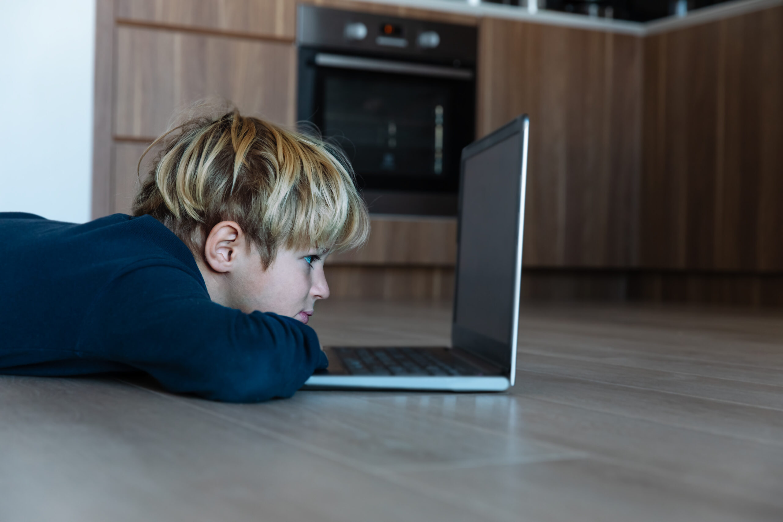 kid looking at computer at home, online learning and remote education