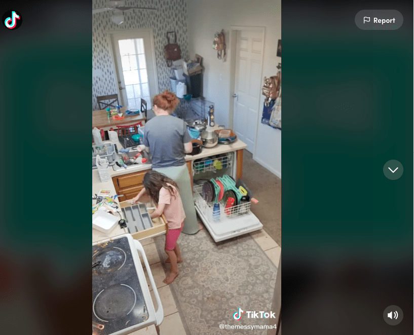 Screenshot of TikTok user @themessymama4 cleaning her house while her daughter helps organize the kitchen 