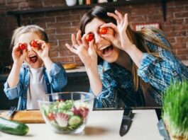 Mom and daughter holding tomatoes to their eyes being silly as they learn to stop caring what others think