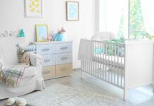 baby nursery with crib, dresser, and glider