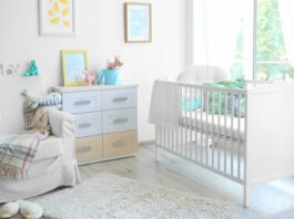 baby nursery with crib, dresser, and glider