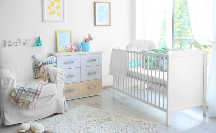 baby nursery with crib, dresser, and glider