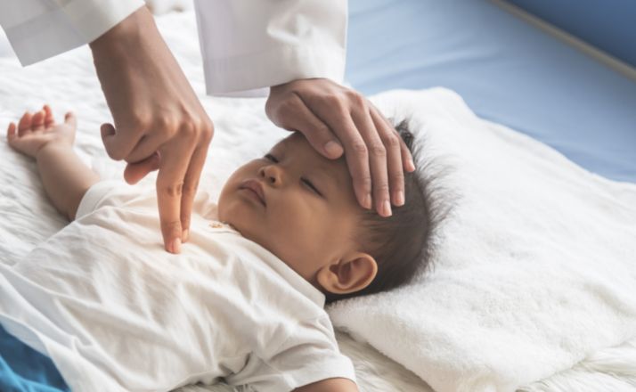 person administering infant cpr on a baby