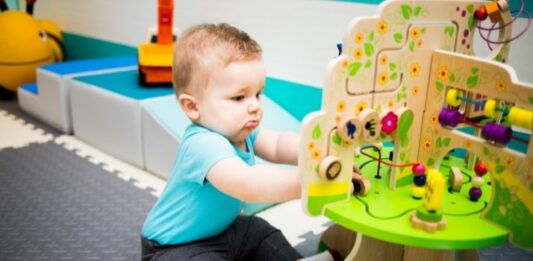 baby playing with toys on the floor of an infant daycare