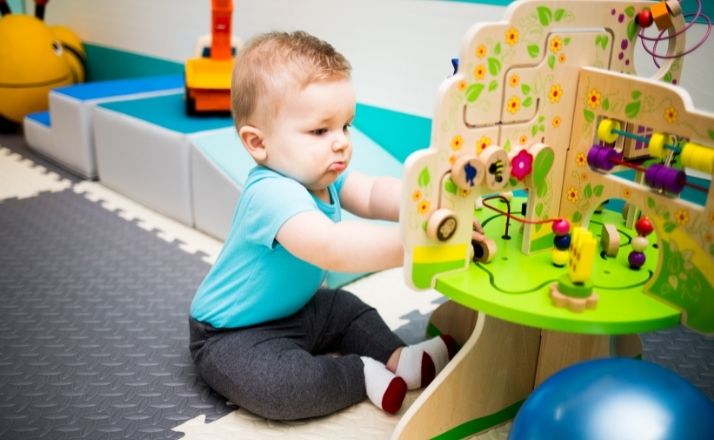 baby playing with toys on the floor of an infant daycare