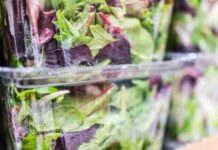 Macro closeup of mixed green salad in boxes on display