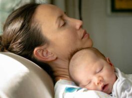 a depressed overwhelmed and tired mom taking care of her baby at home. maternal depression
