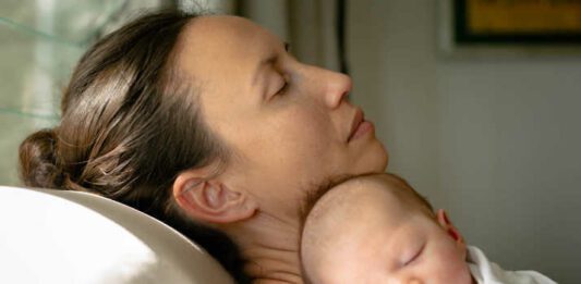 a depressed overwhelmed and tired mom taking care of her baby at home. maternal depression