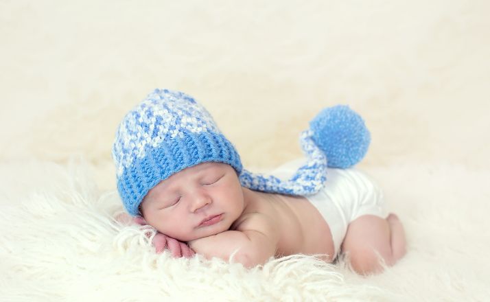 baby boy with winter hat on for newborn photography session