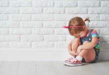 little child girl crying and sad about an empty brick wall