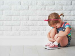 little child girl crying and sad about an empty brick wall