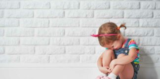 little child girl crying and sad about an empty brick wall