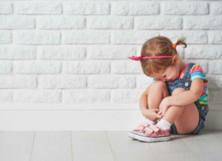 little child girl crying and sad about an empty brick wall