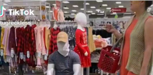 Man dressed as manequinn in Target as mom and daughter walk by