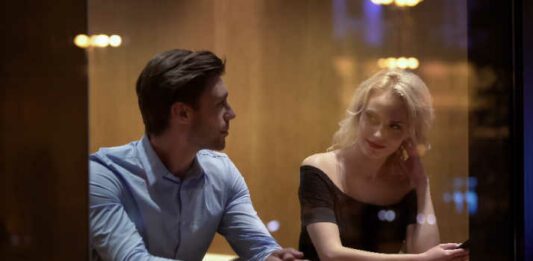 Pretty female flirting with young man at cafe, evening time, pick-up and date