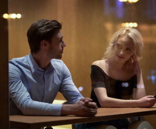 Pretty female flirting with young man at cafe, evening time, pick-up and date
