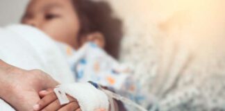Mother hand holding child hand who have IV solution in the hospital with love and care