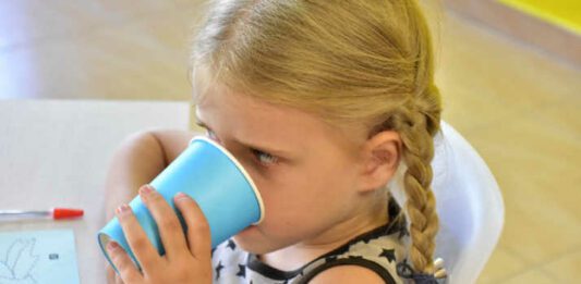 Kindergarten girl drinking at snack time