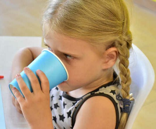 Kindergarten girl drinking at snack time
