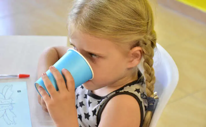 Kindergarten girl drinking at snack time