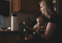 mom working at computer with child in her lap