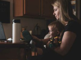 mom working at computer with child in her lap