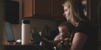 mom working at computer with child in her lap