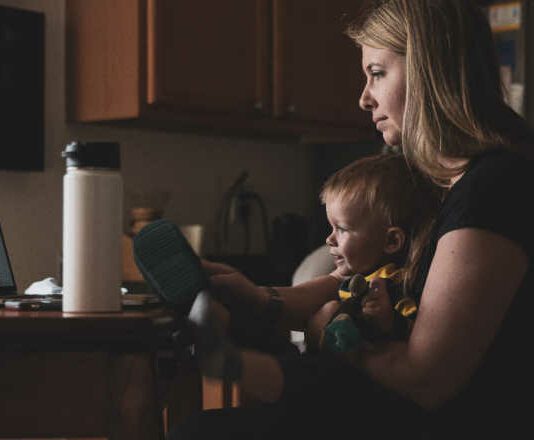 mom working at computer with child in her lap