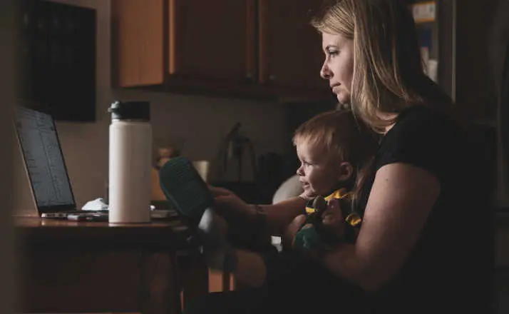 mom working at computer with child in her lap