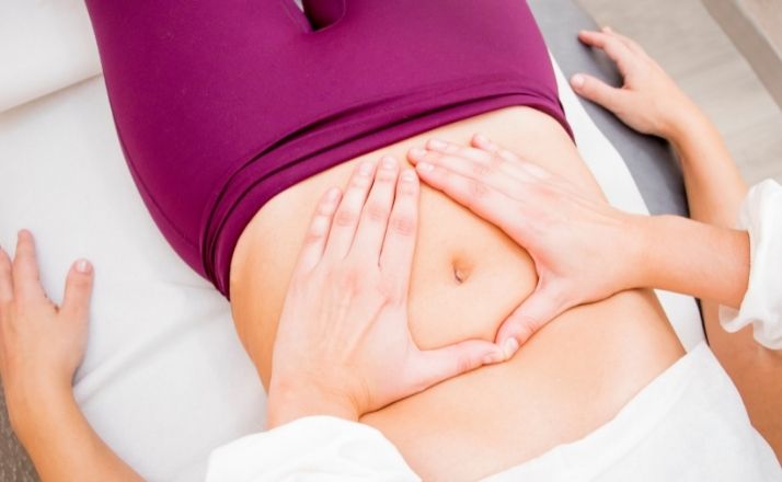 woman receiving pelvic floor therapy to her lower stomach while lying on her back