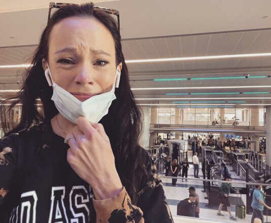 Screenshot of Facebook post woman in airport crying with mask