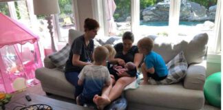 mom with newborn, midwife and older kids sitting on couch