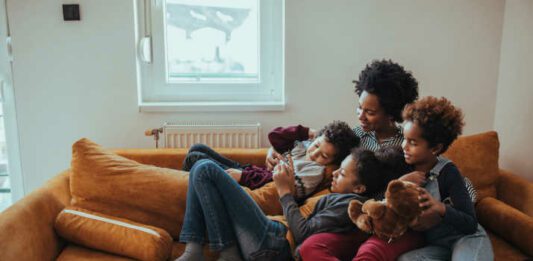 Shot of a mother looking at something on the mobile phone with her children