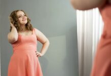 woman smiling in mirror to show how my body image is not for anyone else to judge