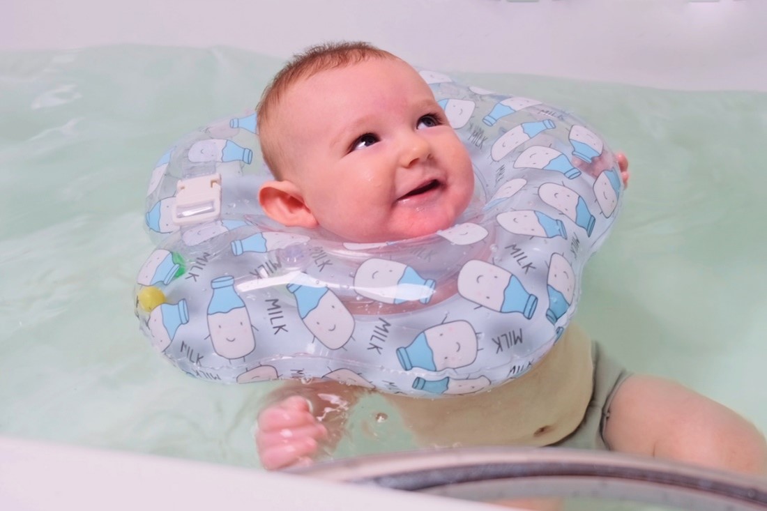 baby wearing neck float in water