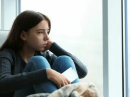 teen with depression looking out window