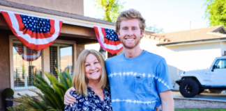 Photo of mother and son standing in front of a house.