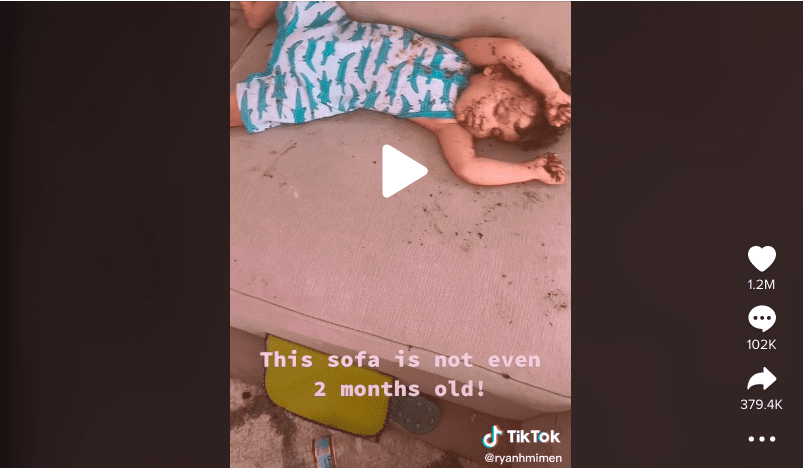 Screenshot of toddler asleep on a messy couch.