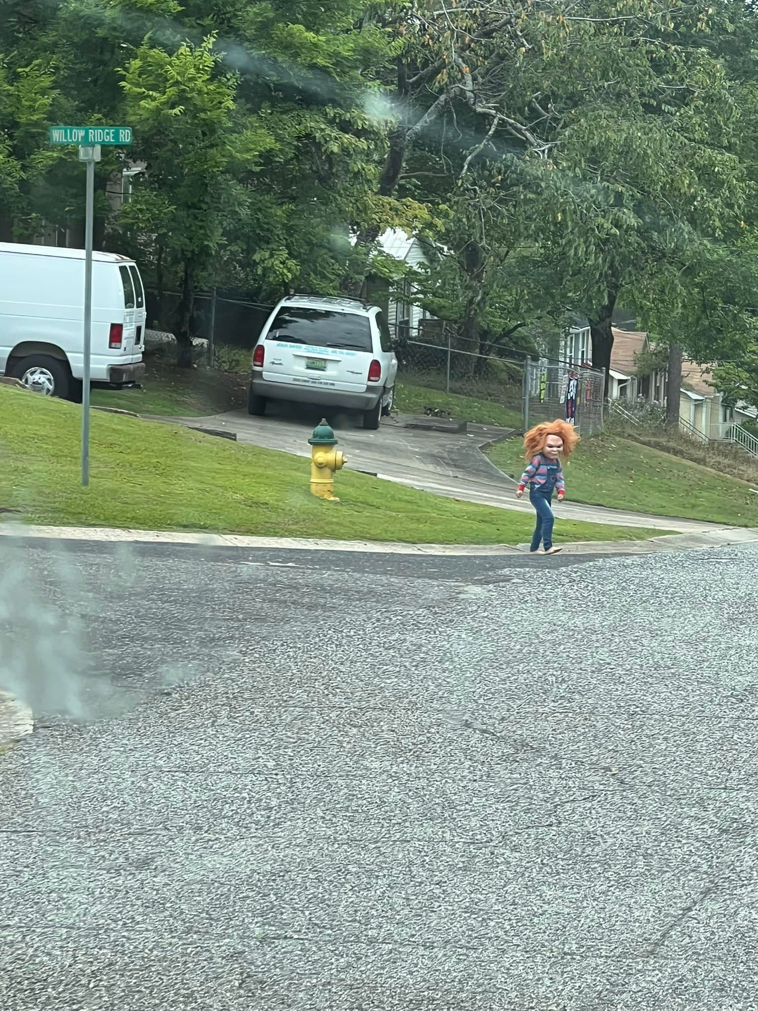 boy dressed in Chucky costume standing on street