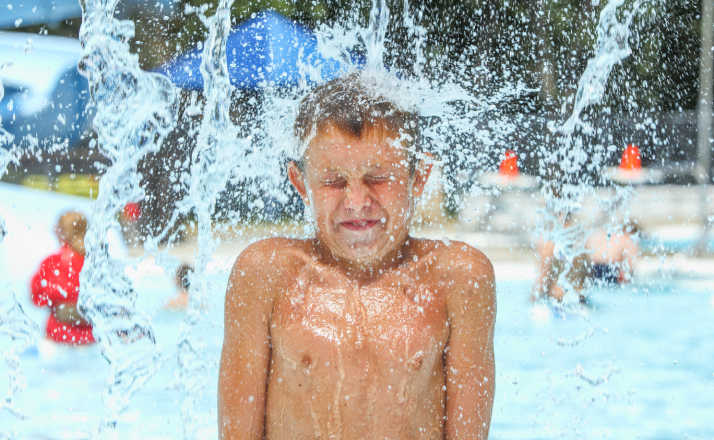 Boy at waterpark being hit with icy cold water