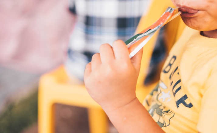 Capri sun recall Young boy drinking juice from disposable plastic pouch. Selective focus.