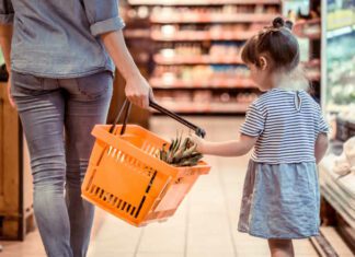 mom and daughter shopping in grocery store because of high cost of having kids