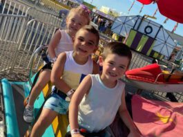 three kids sitting on fair rides