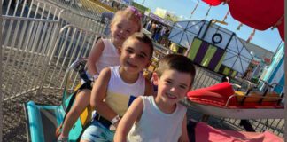 three kids sitting on fair rides