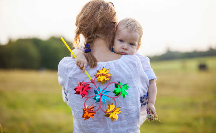 mom holding little boy holding pinwheel