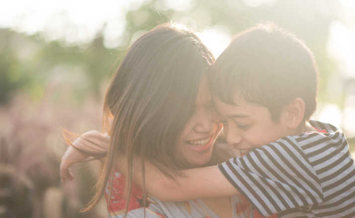 Single mom walking with son together with happy face