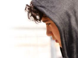 teen wearing a hoodie and looking sad why teens wear hoodies
