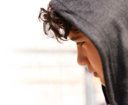 teen wearing a hoodie and looking sad why teens wear hoodies
