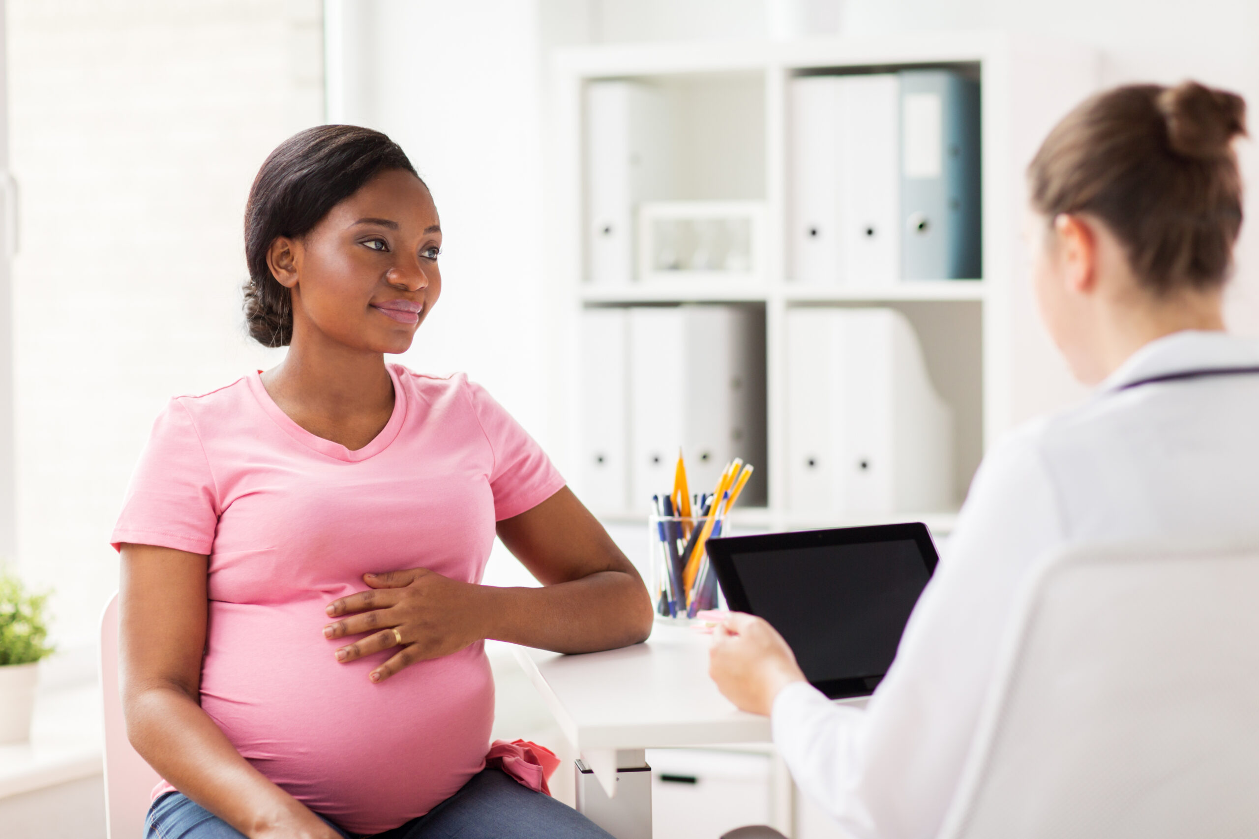 doctor with tablet pc and pregnant woman at clinic